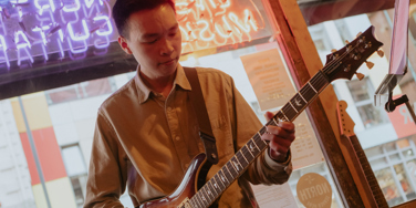 Bryan Chung Biography Photo - Bryan playing a guitar