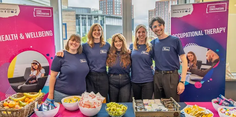 Image: health and wellbeing staff at stall smiling