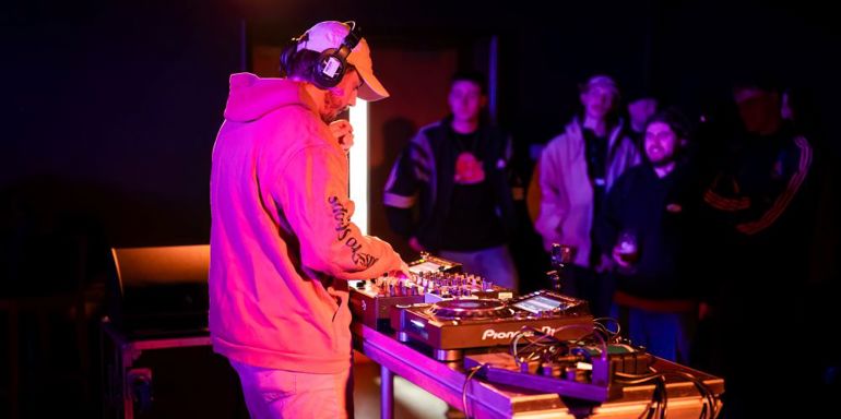 Student DJing with crowd watching