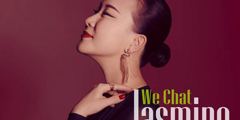 Jasmine Chen We Chat artwork. Headshot, looking up with eyes closed, wearing a black dress, against burgundy background